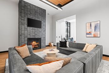 a living room with a gray couch and a fireplace
